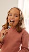 photo of a young girl eating peanut-free spread off of a spoon